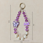 Beaded keychain with butterfly charm and measurements on a beige background