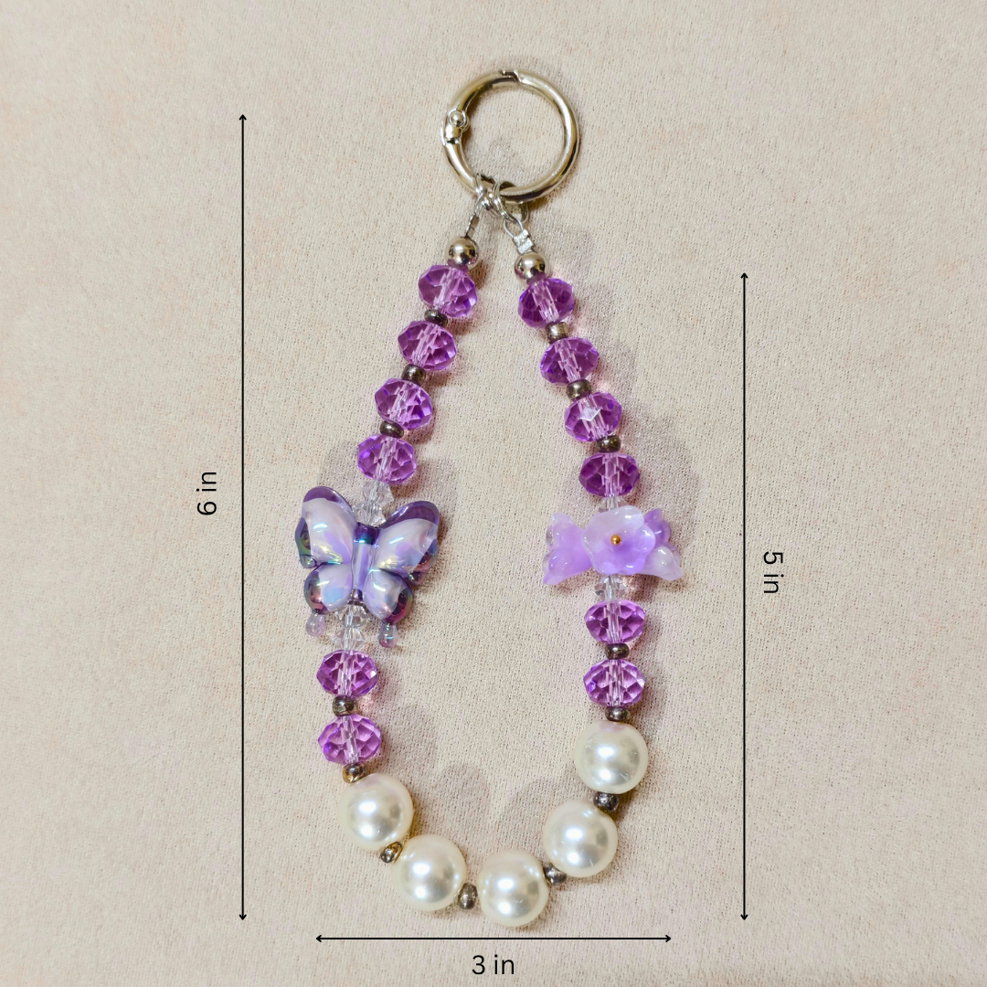 Beaded keychain with butterfly charm and measurements on a beige background