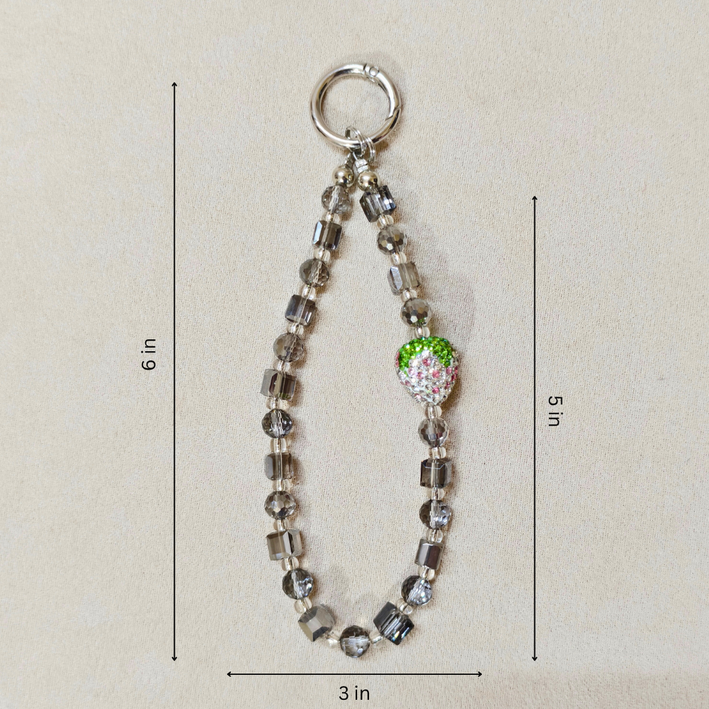 Beaded keychain with a green apple charm on a beige background