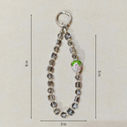 Beaded keychain with a green apple charm on a beige background