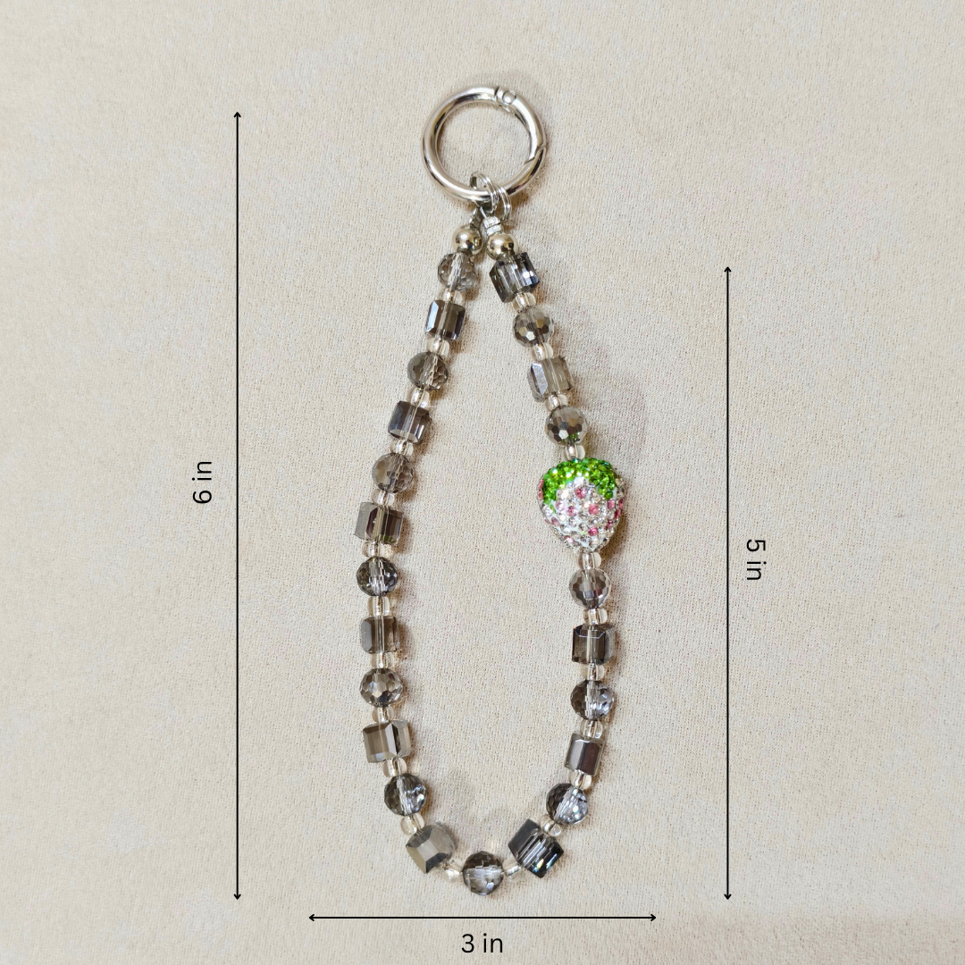 Beaded keychain with a green apple charm on a beige background