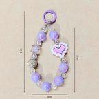Purple beaded keychain with heart-shaped charm on a beige background