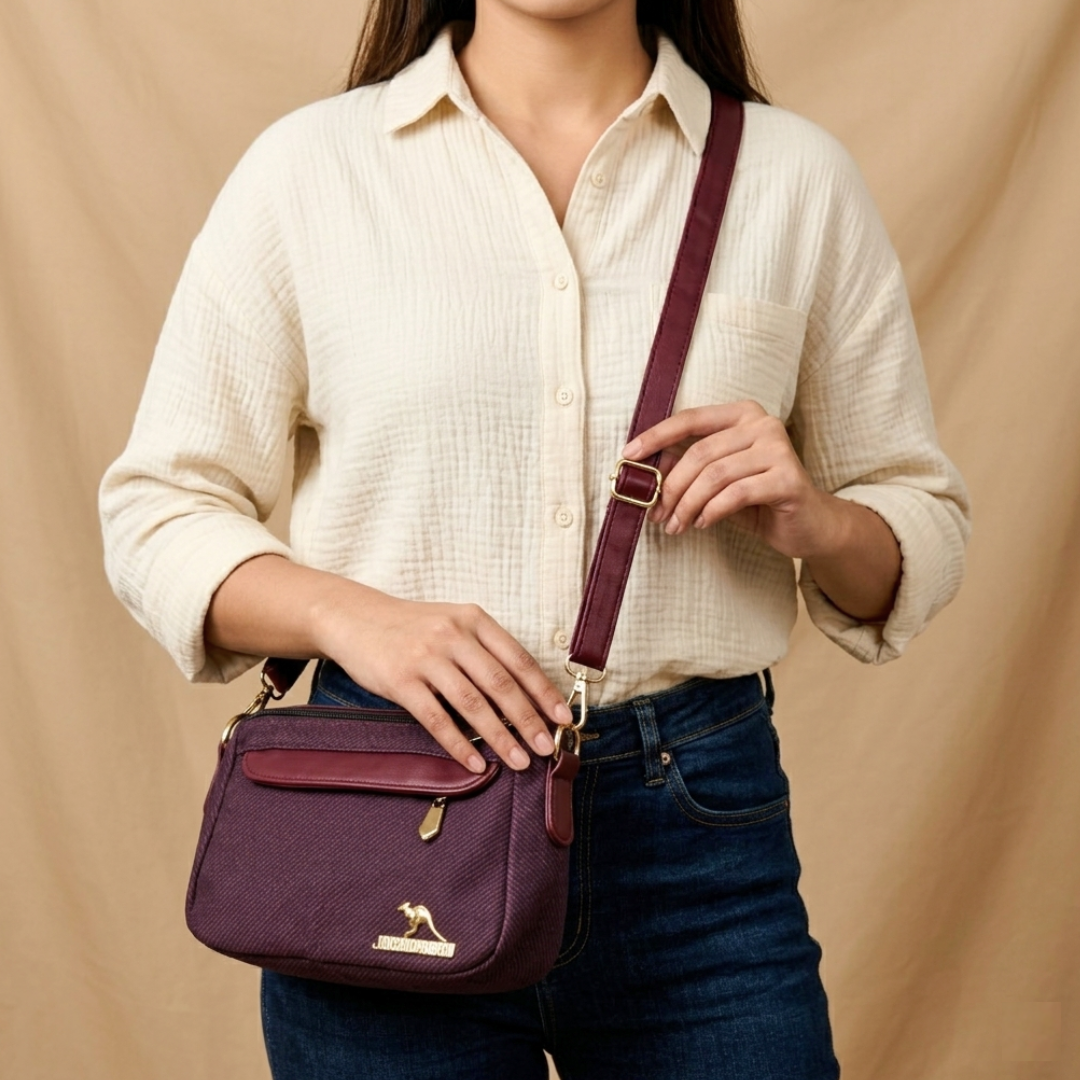 Person holding a purple handbag with a visible brand logo against a beige background
