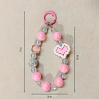Pink beaded keychain with measurements on a beige background