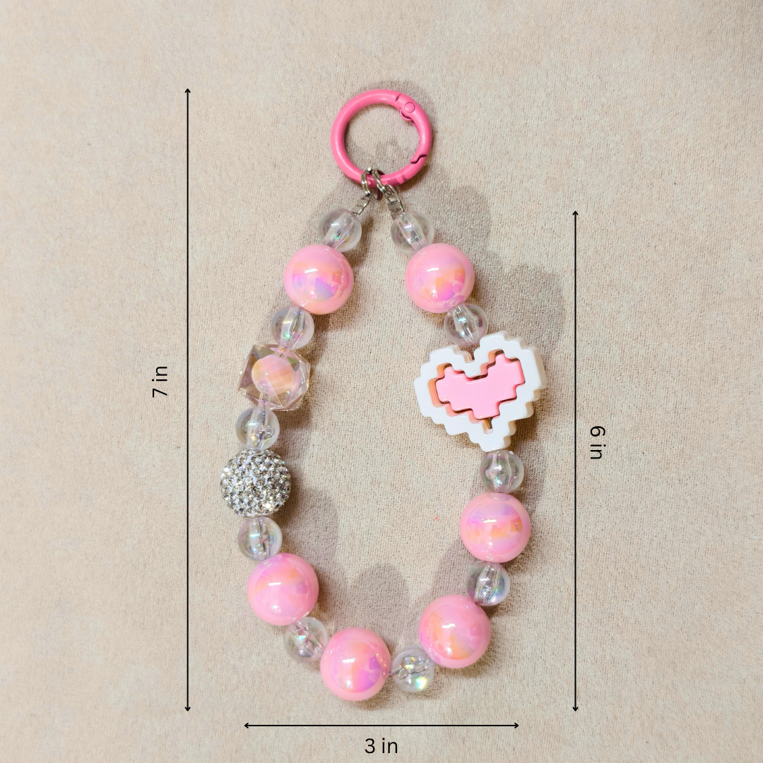 Pink beaded keychain with measurements on a beige background