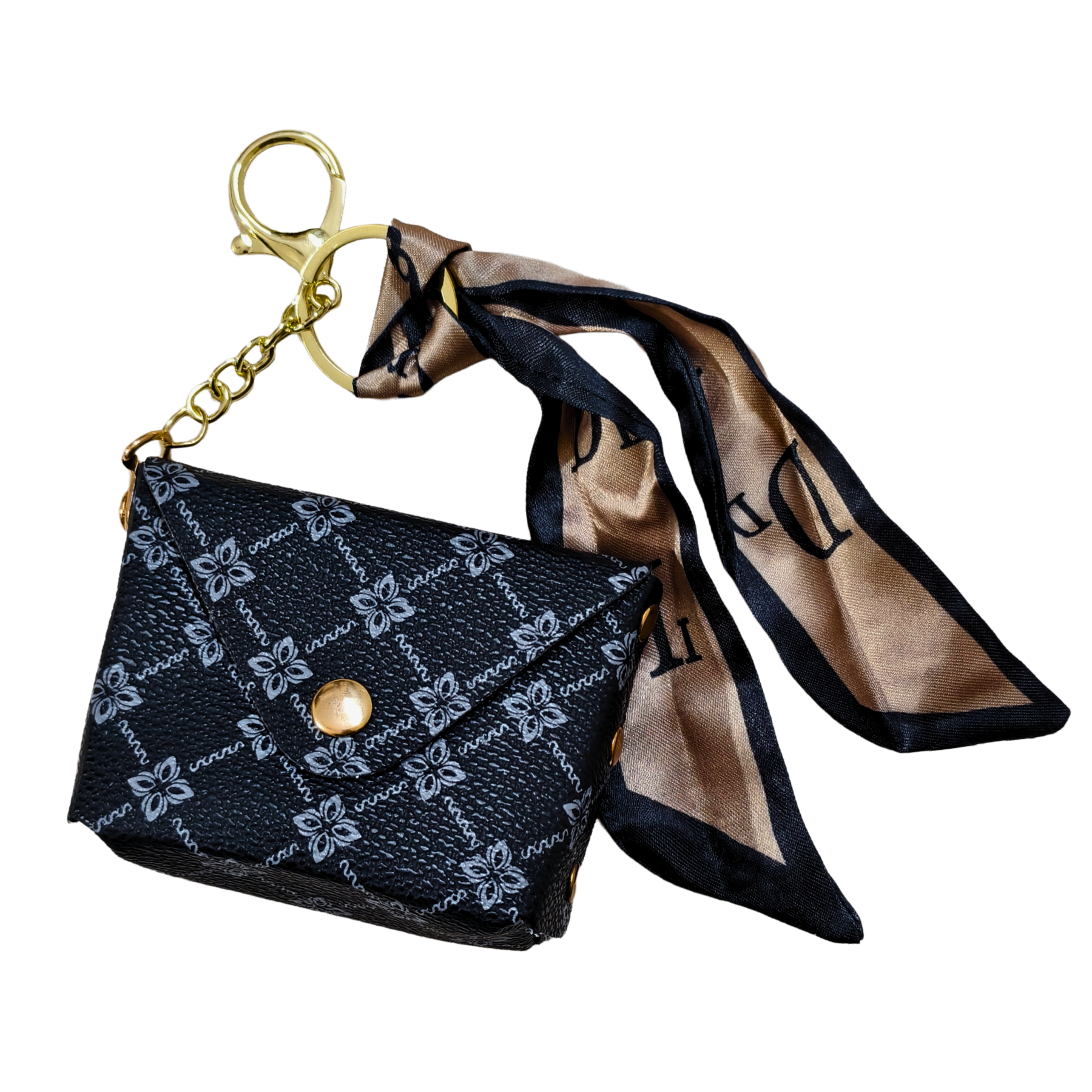 Black patterned purse charm with gold chain and beige scarf on a white background