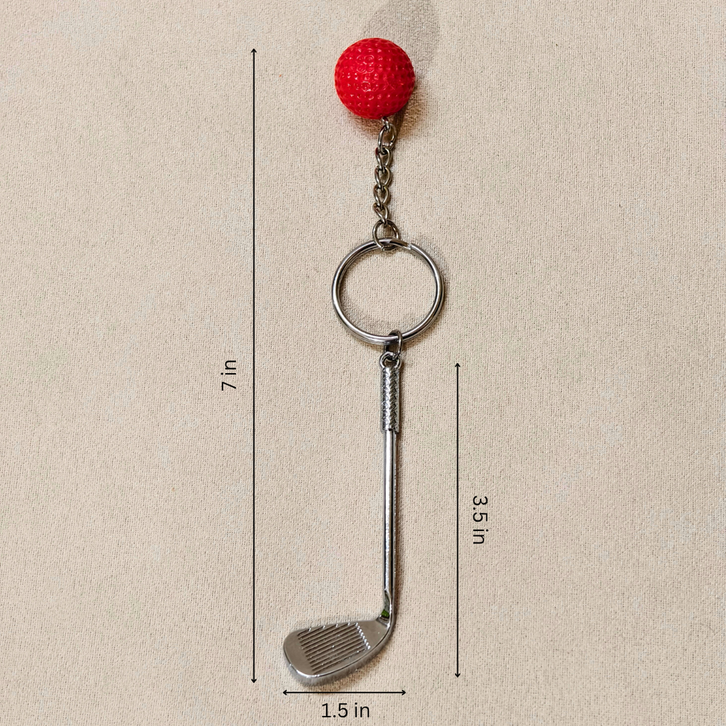 A golf club-shaped keychain with a red textured ball on top, shown on a beige background with dimension lines and labels indicating 7 in total height, 3.5 in shaft height, and 1.