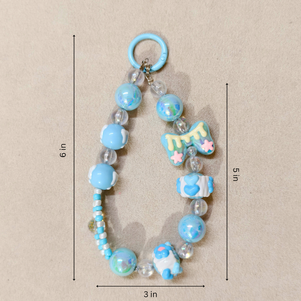 Decorative keychain with blue beads and charms on a beige background