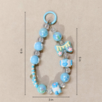 Decorative keychain with blue beads and charms on a beige background
