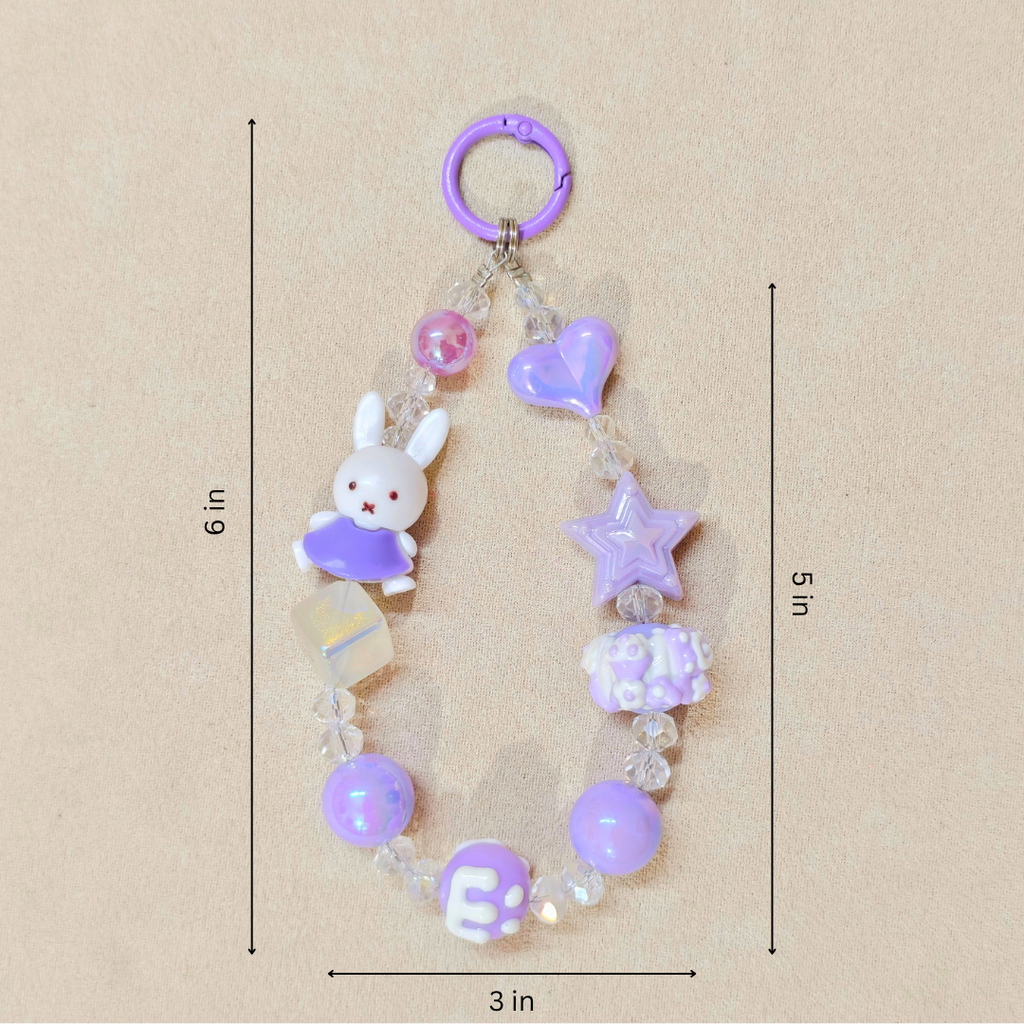 Decorative keychain with beads and charms on a beige background