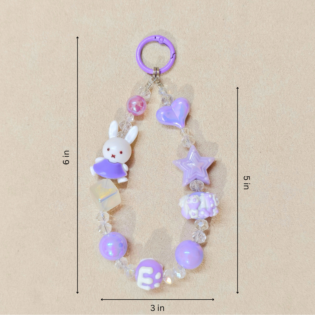 Decorative keychain with beads and charms on a beige background