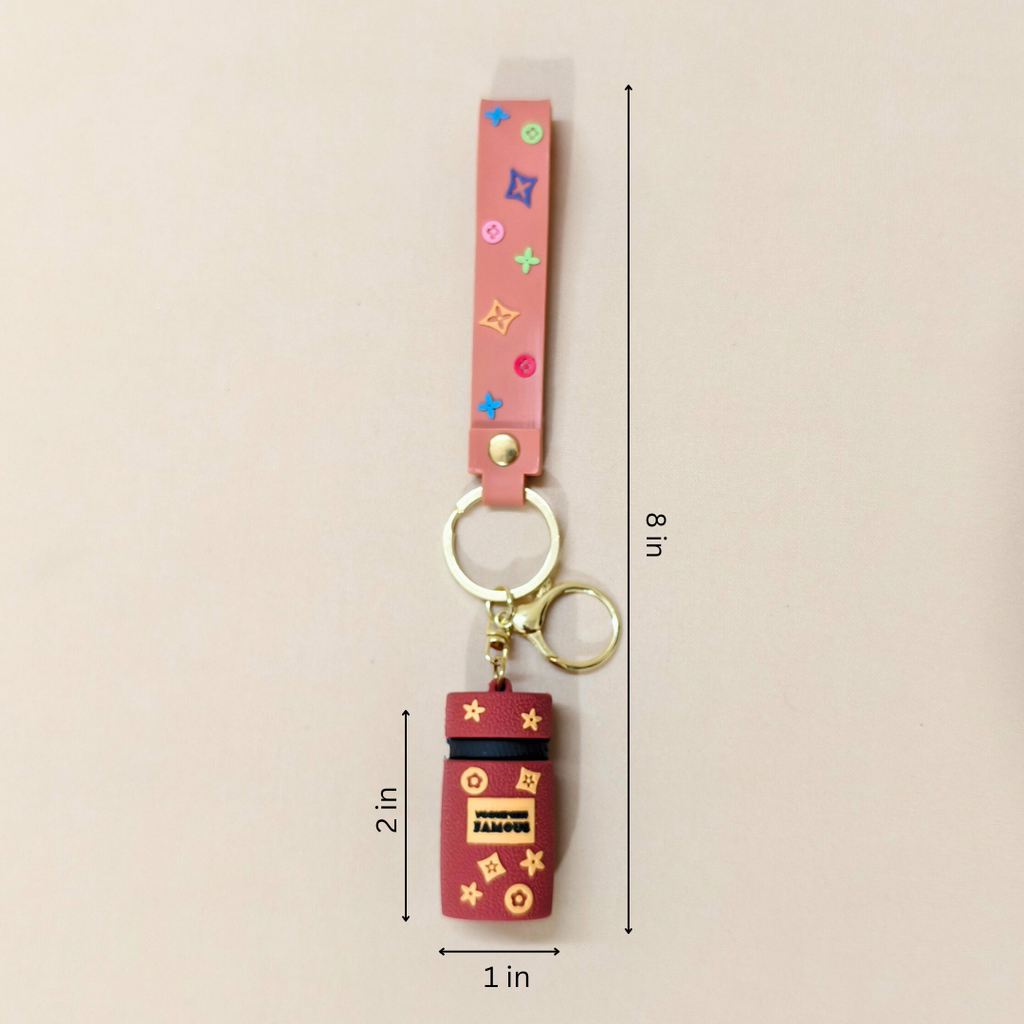 Keychain with colorful strap and red charm on a beige background
