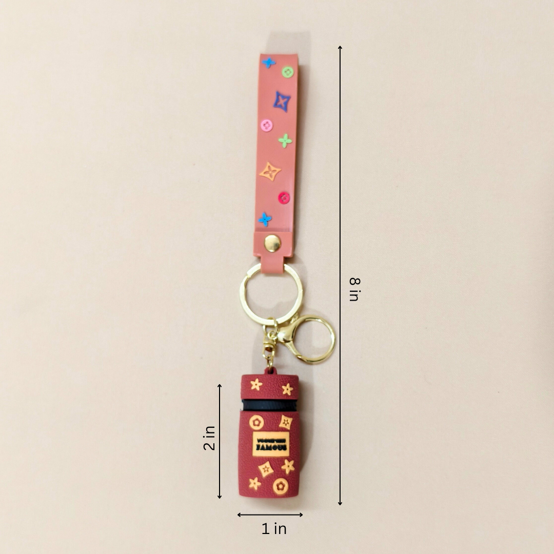 Keychain with colorful strap and red charm on a beige background