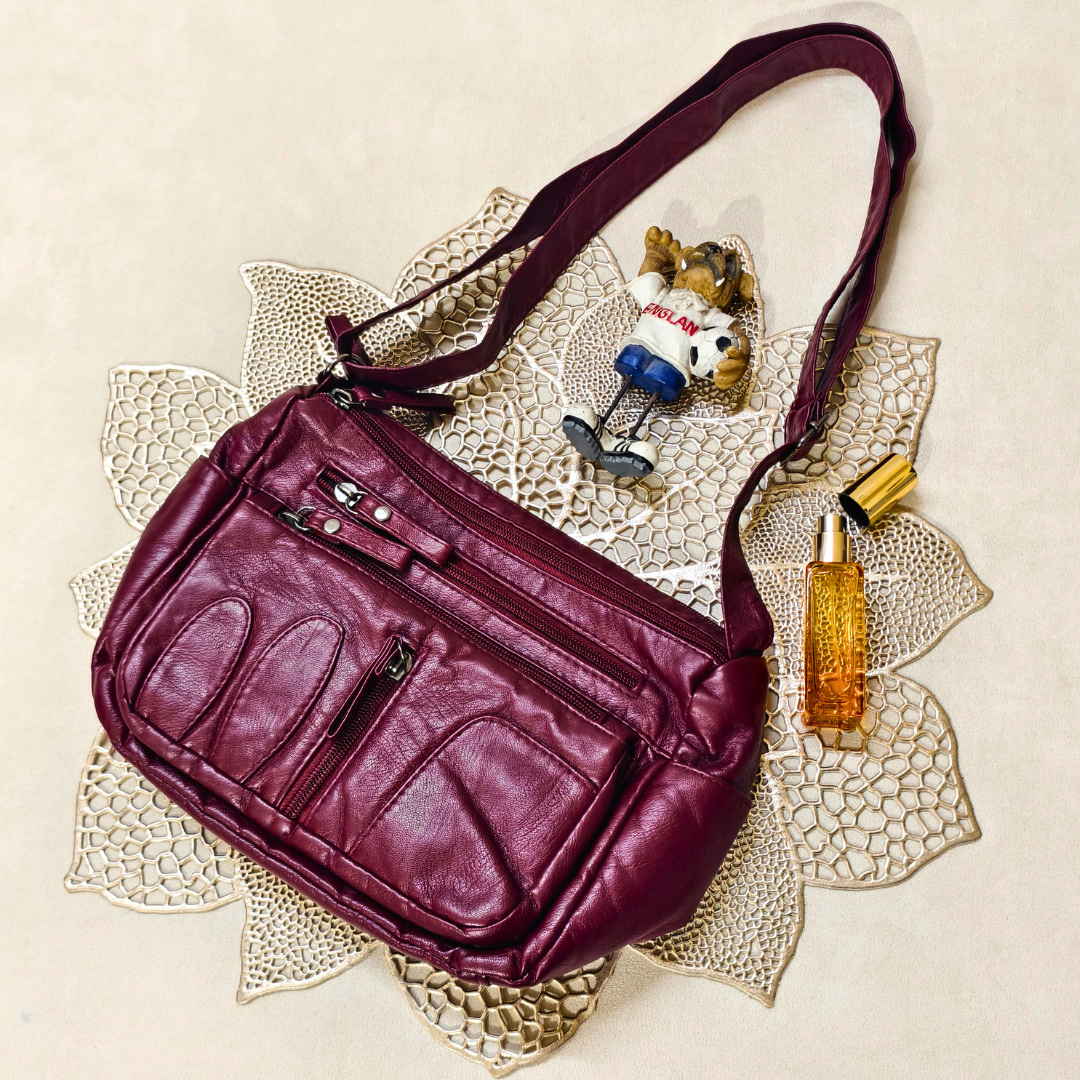 Purple handbag on a decorative doily with a small figurine and bottle of perfume.