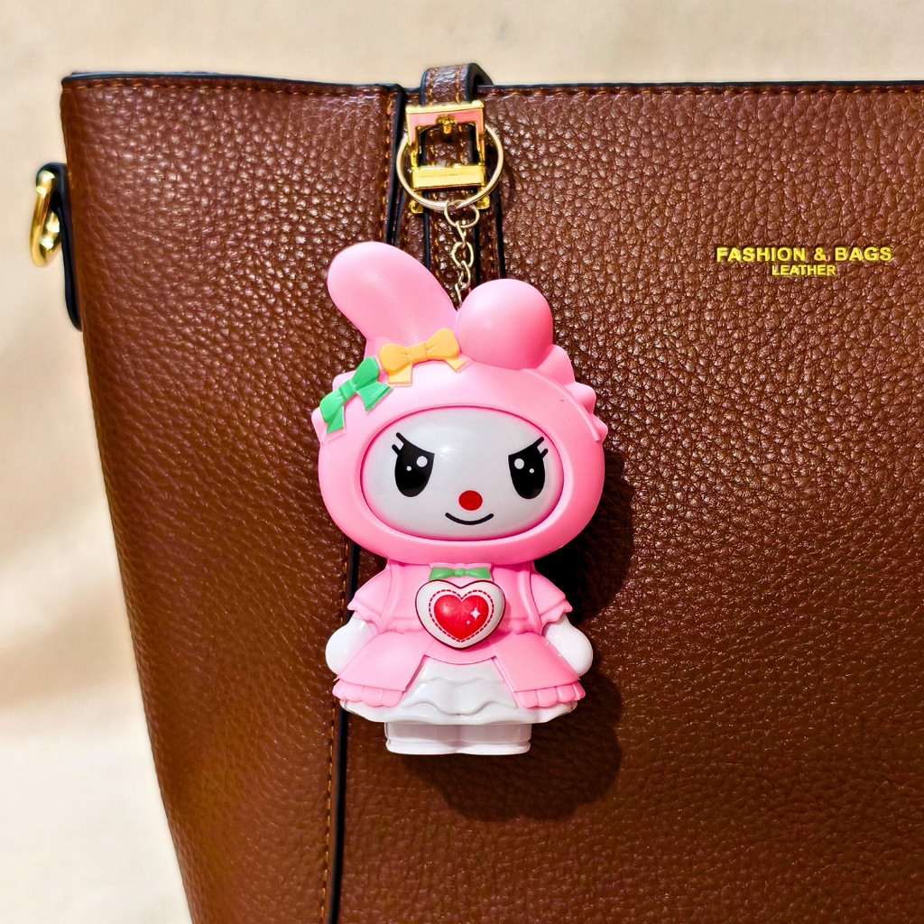 Pink cartoon character keychain on a brown leather bag with 'Fashion & Bags' branding.