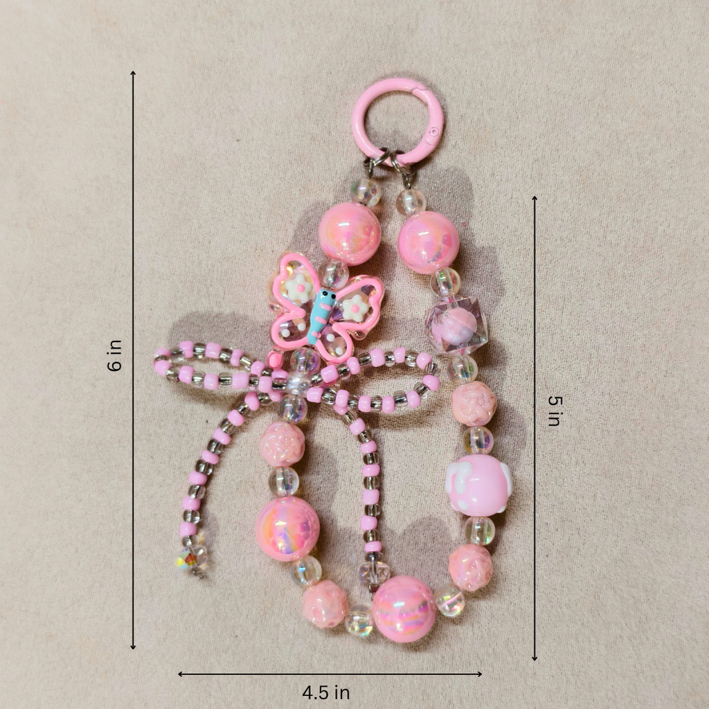 Pink beaded keychain with measurements on a beige background