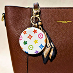 Round LV White Pocket Mirror Attached With Purse As  Bag Charm On  Beige Background.