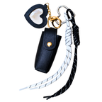 Black leather keychain pouch with heart-shaped cover, white and black braided lanyard, and gold ring on a white background.