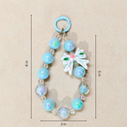 Decorative keychain with beads and a bow, shown with measurements on a beige background