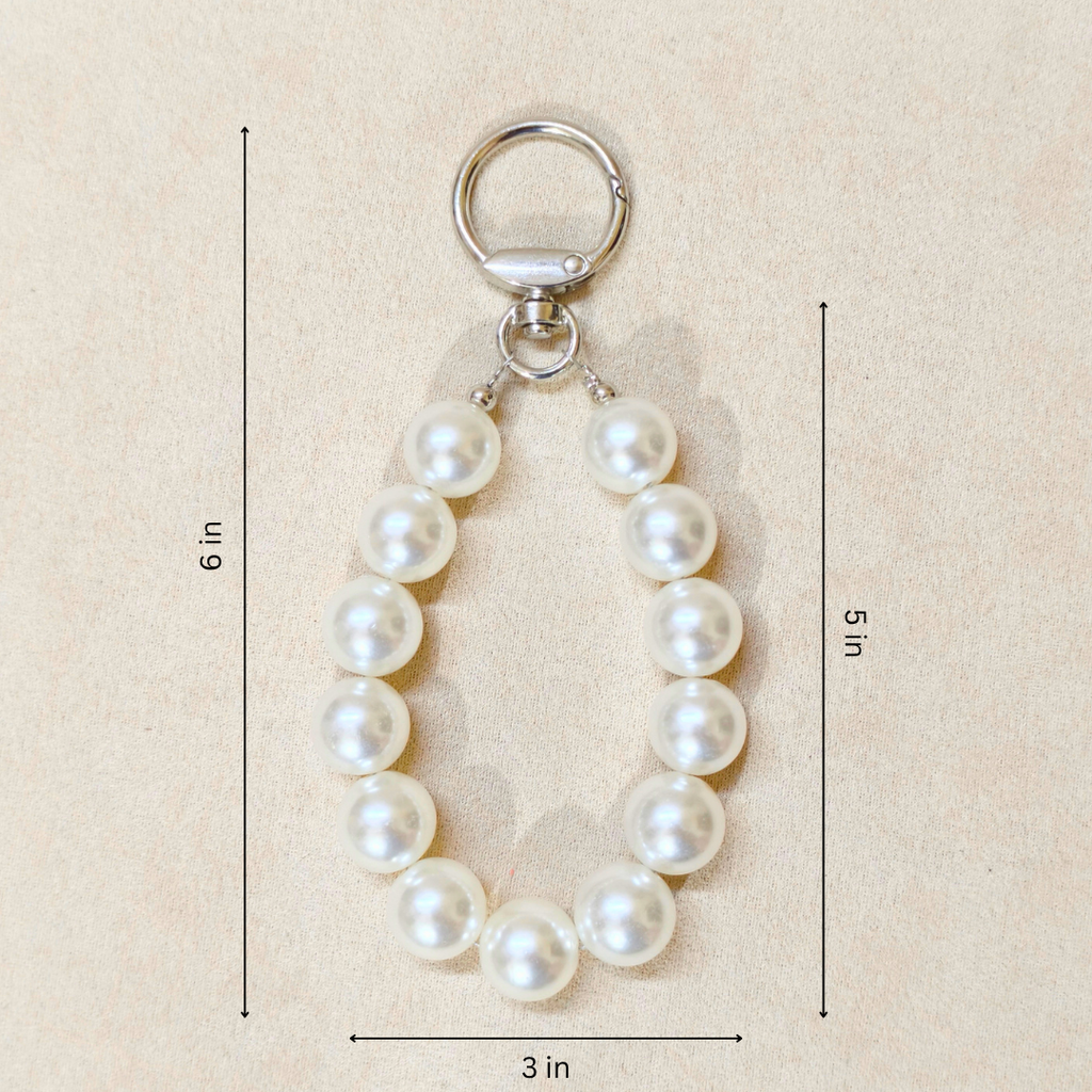 Pearl keychain with measurements on a beige background