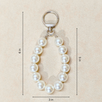 Pearl keychain with measurements on a beige background