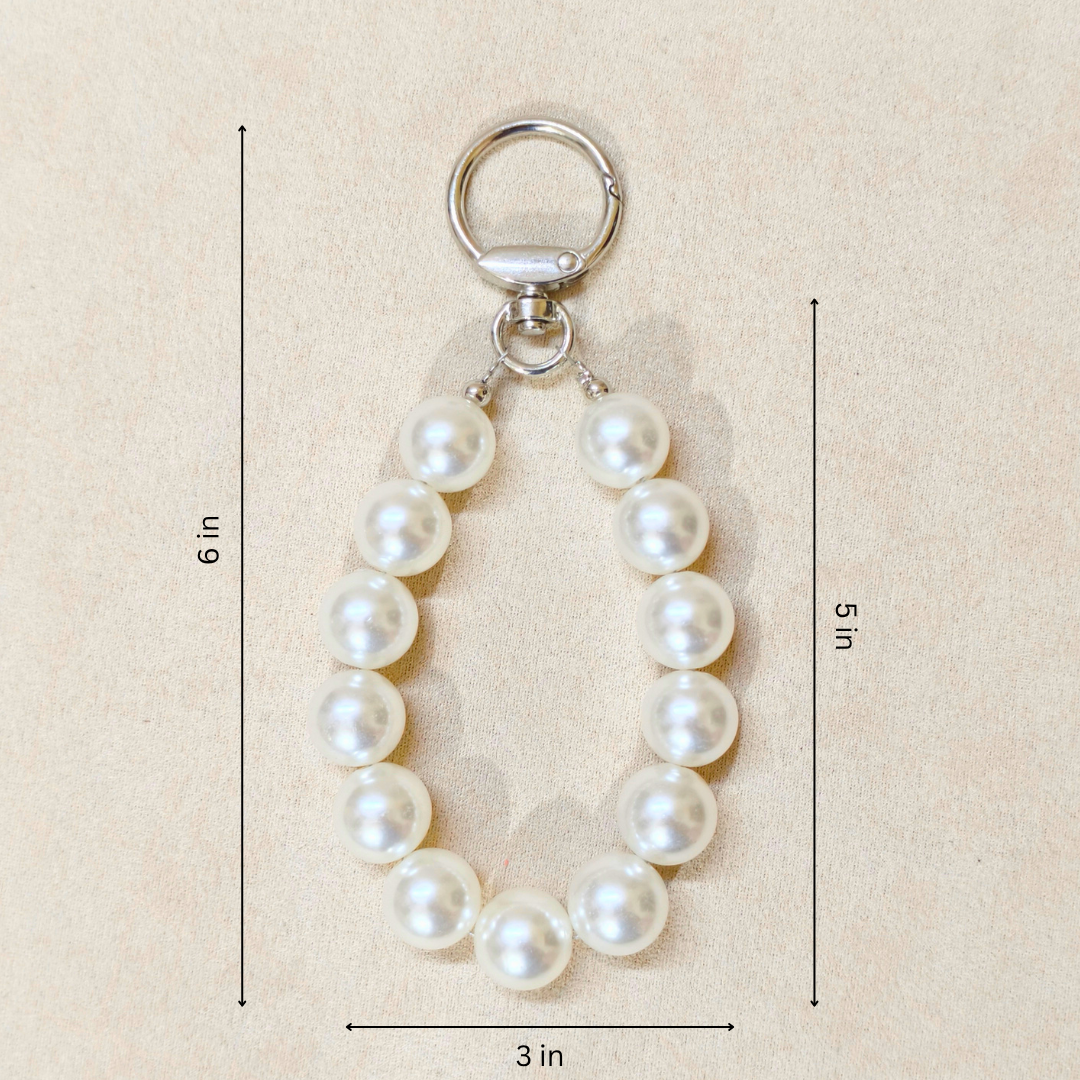 Pearl keychain with measurements on a beige background