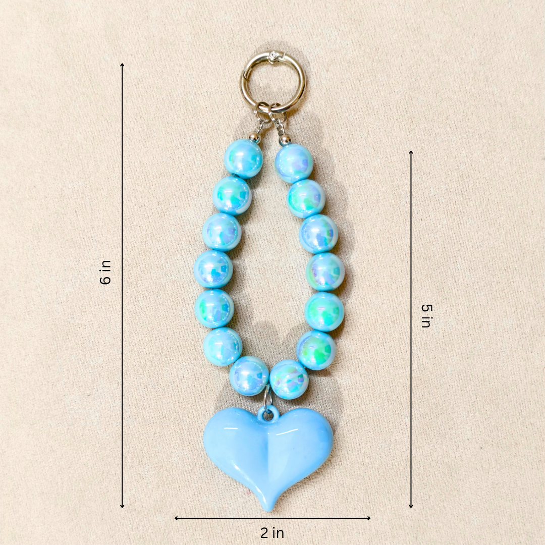 Blue beaded keychain with a heart-shaped pendant on a beige background