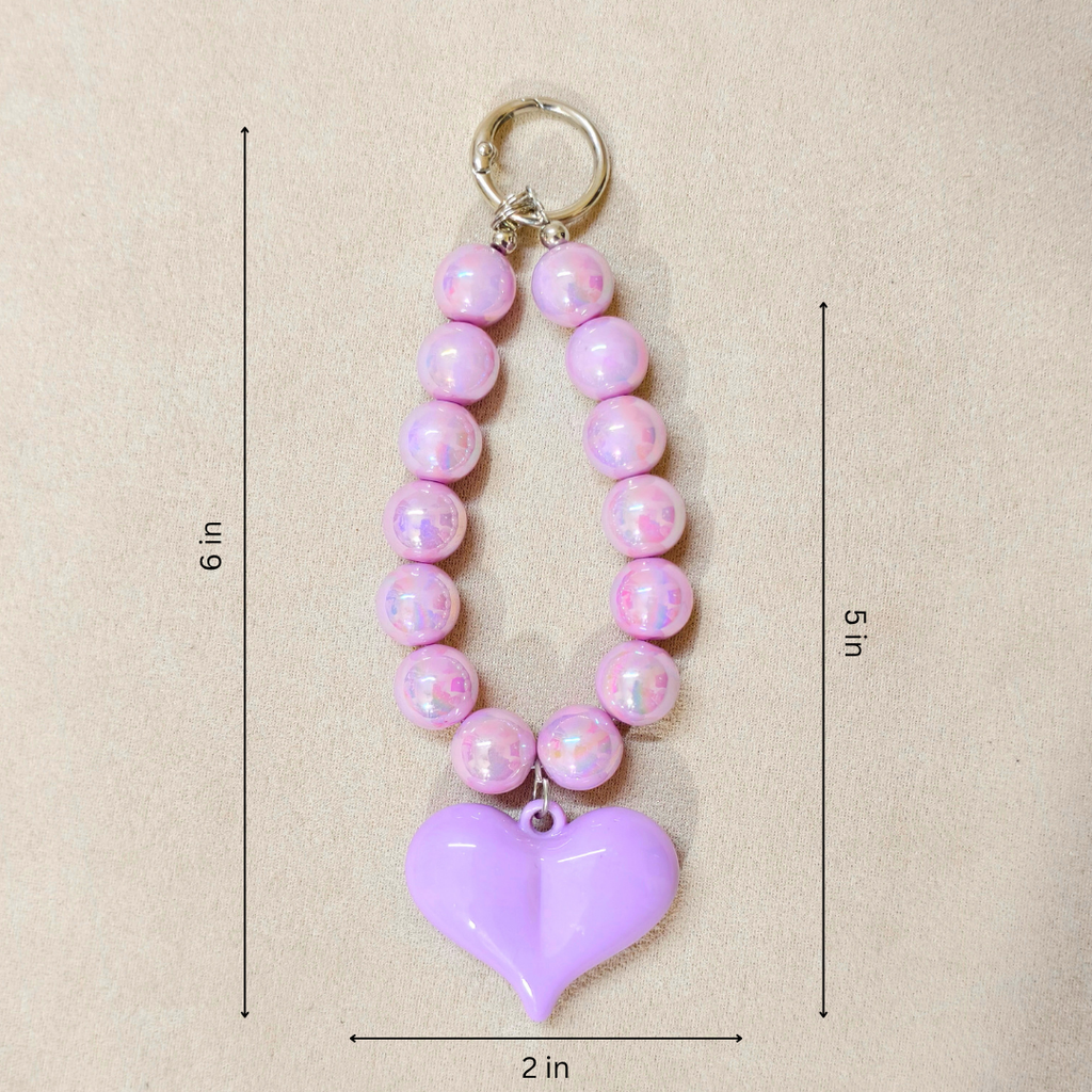 Pink beaded keychain with a purple heart pendant on a beige background