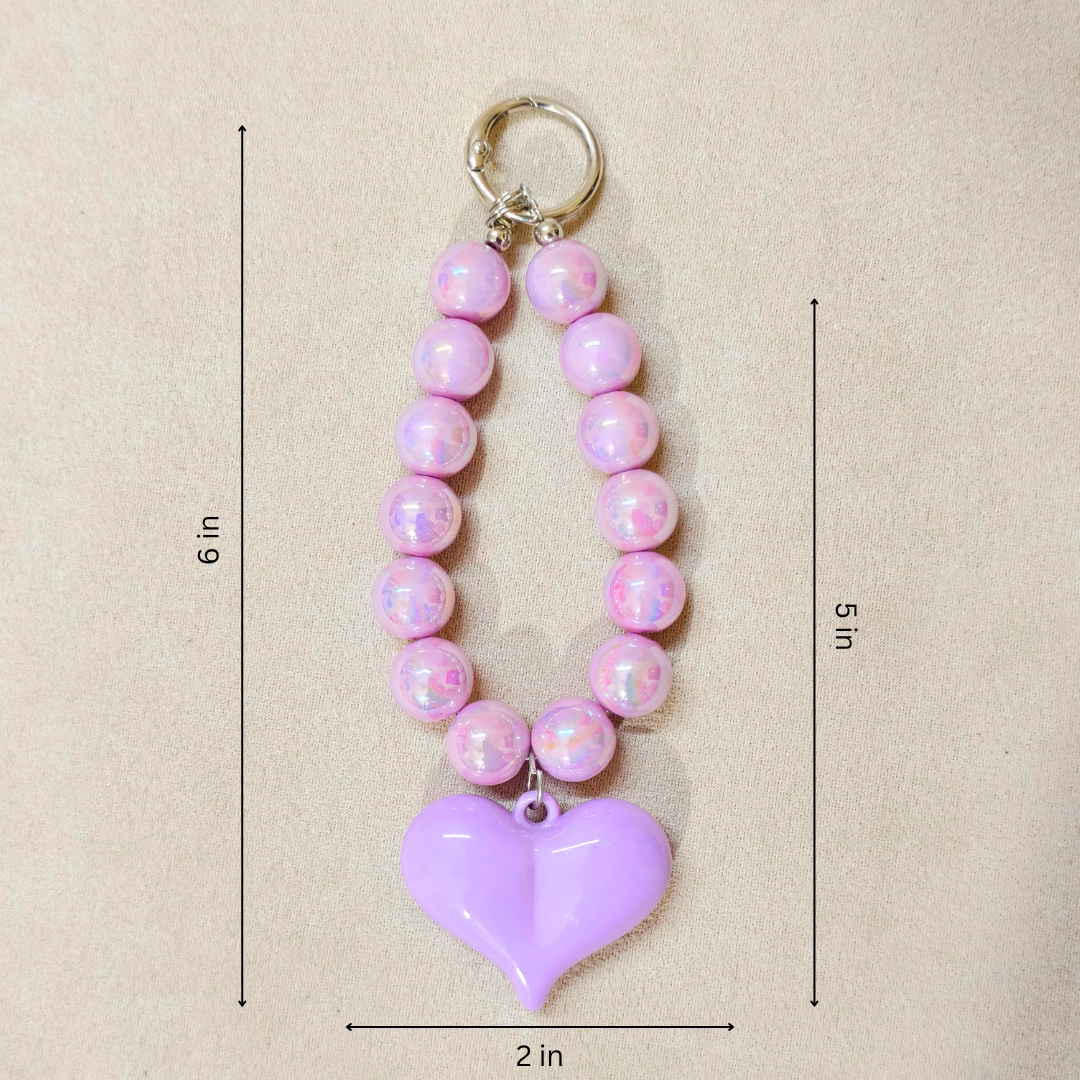 Pink beaded keychain with a purple heart pendant on a beige background