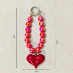 Beaded keychain with a heart charm on a beige background