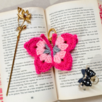 Pink butterfly-shaped crochet keychain on an open book