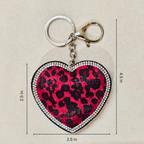Heart-shaped keychain with leopard print design and measurements on a beige background