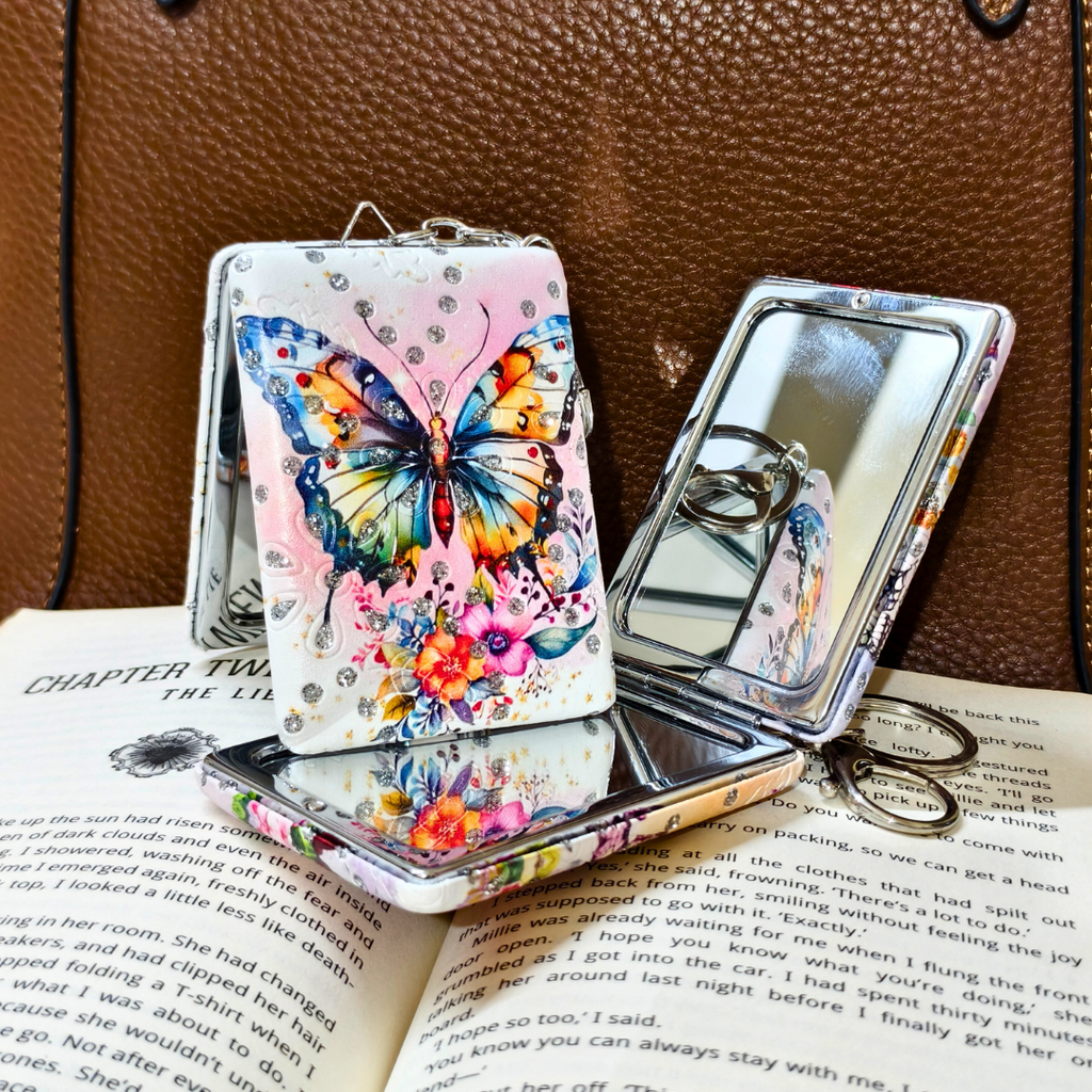 Butterfly-themed phone case with mirror on an open book