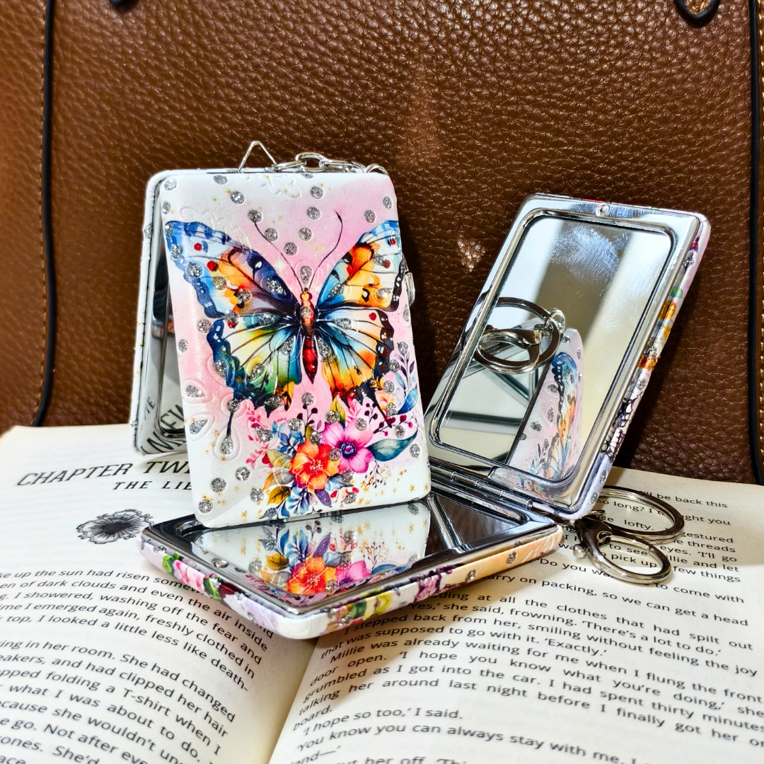 Butterfly-themed phone case with mirror on an open book