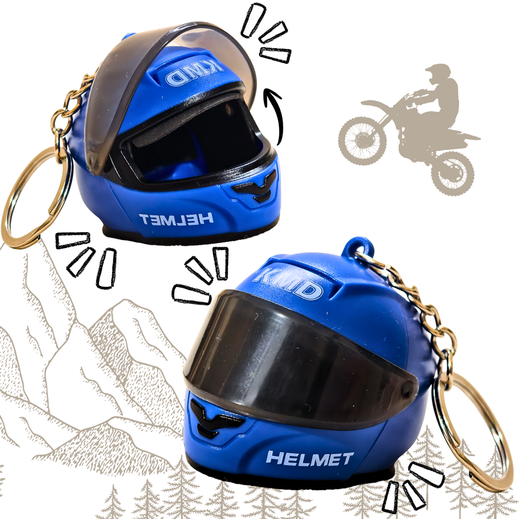 Two blue motorcycle helmet keychains with gold split rings, shown on a white background with decorative line drawings of mountains, trees, and a motorcycle silhouette.