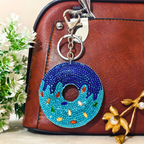 Decorative keychain on a brown leather bag with flowers in the background