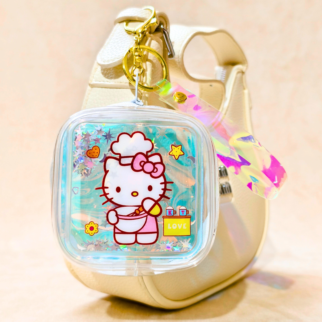Hello Kitty keychain with a gold carabiner on a beige background