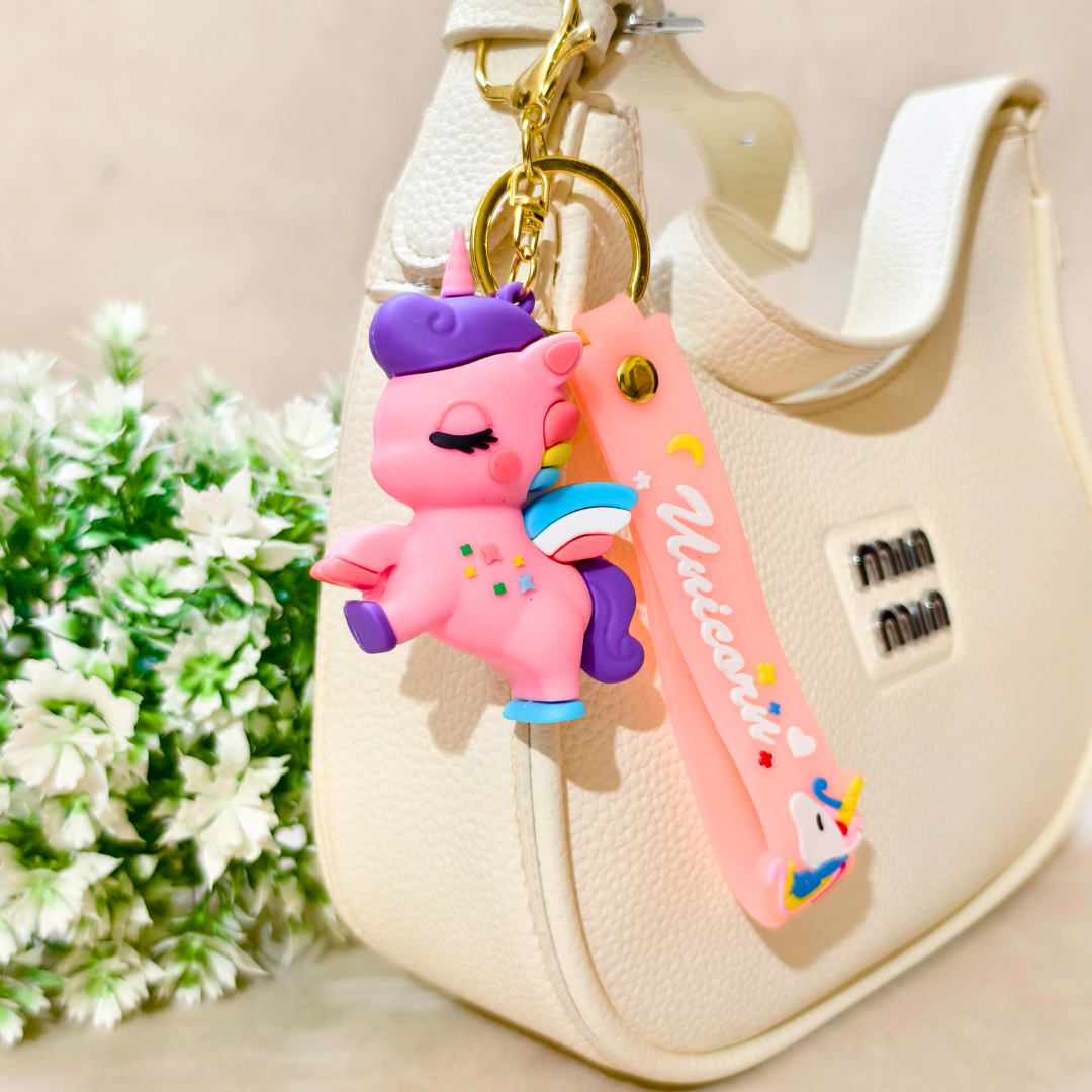 Pink cartoon character keychain with a knife attached to a beige handbag with flowers in the background.