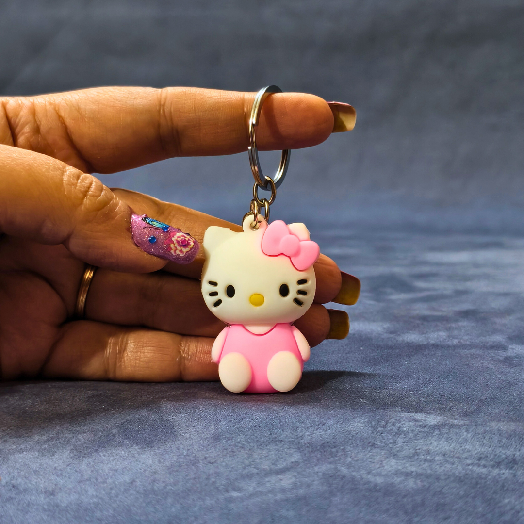 Hand holding a Hello Kitty keychain against a blue background