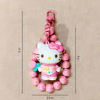 Hello Kitty keychain with pink beads on a beige background