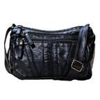 Black leather handbag with multiple zippers on a white background