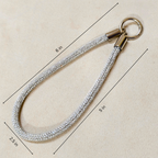 Measurement chart of a keychain with a rope-like strap on a beige background