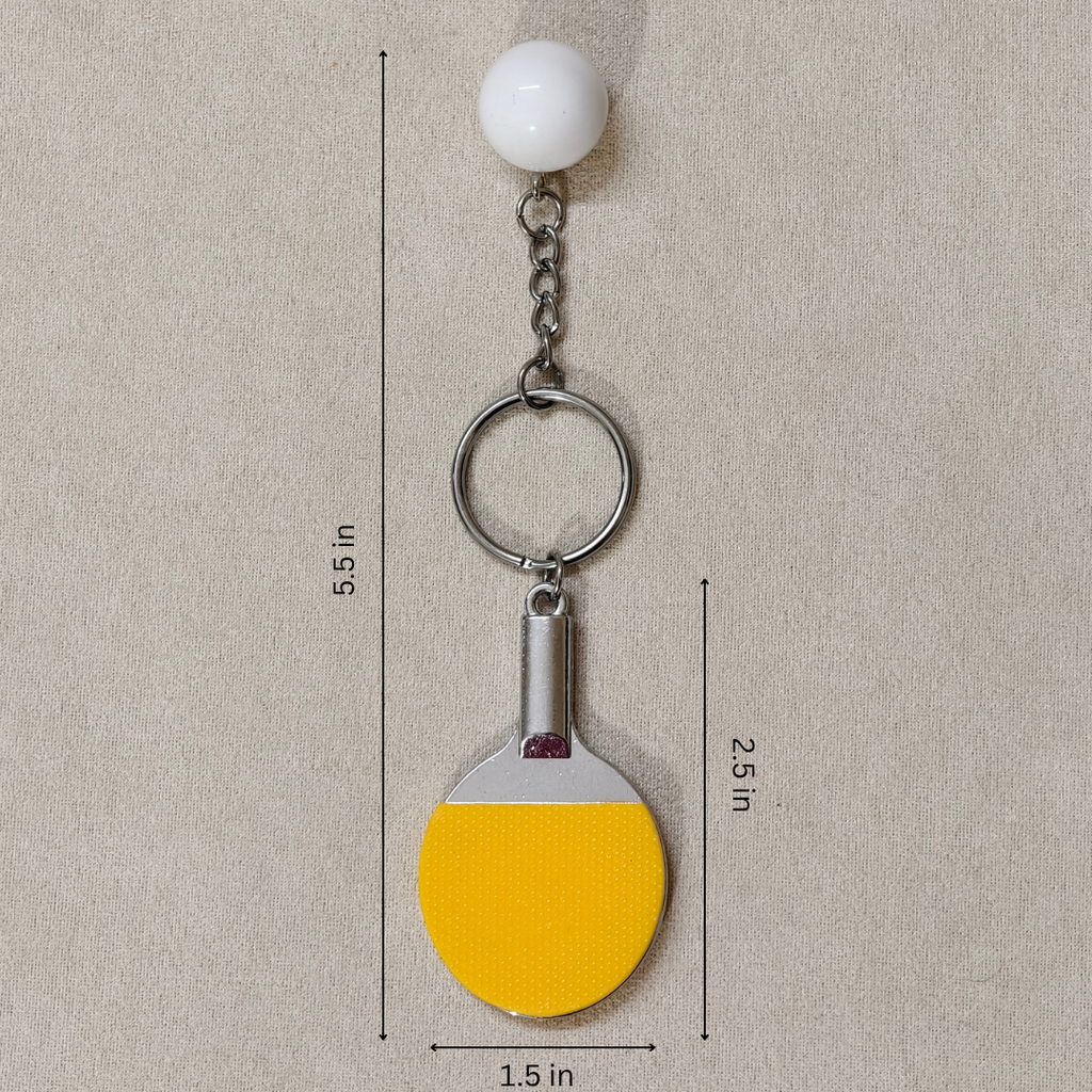 A miniature table tennis keychain charm, featuring a yellow and black paddle with a small white ball and silver metal key ring showing measurement.