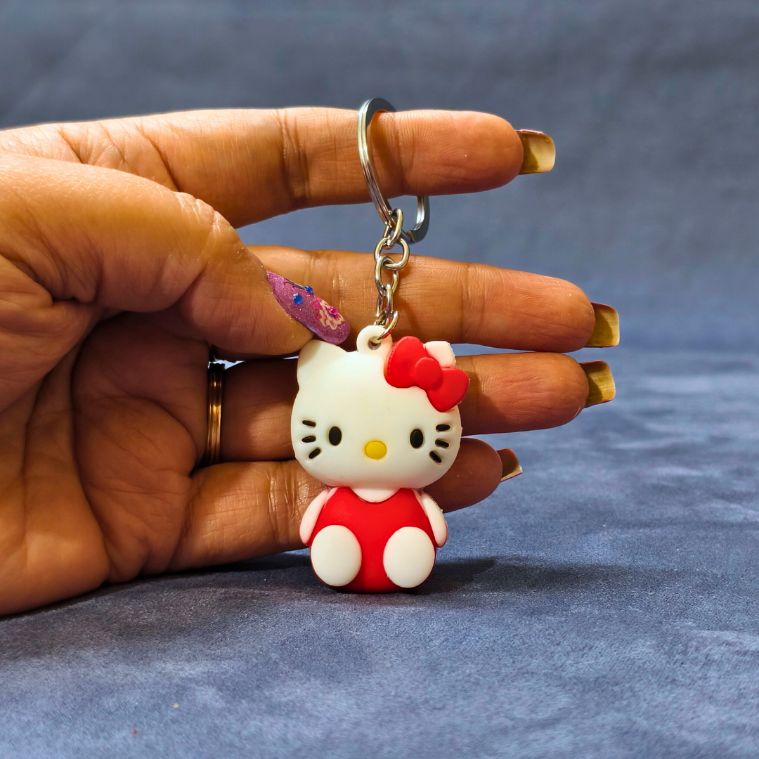 Hand holding a Hello Kitty keychain against a gray background