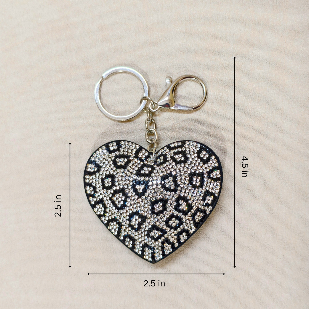 Heart-shaped keychain with leopard print pattern and measurements on a beige background