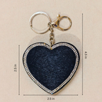 Heart-shaped keychain with measurements on a beige background