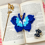Evil Eye Blue Crochet Key Chain Displayed With Props In The Front Of Beige Background.
