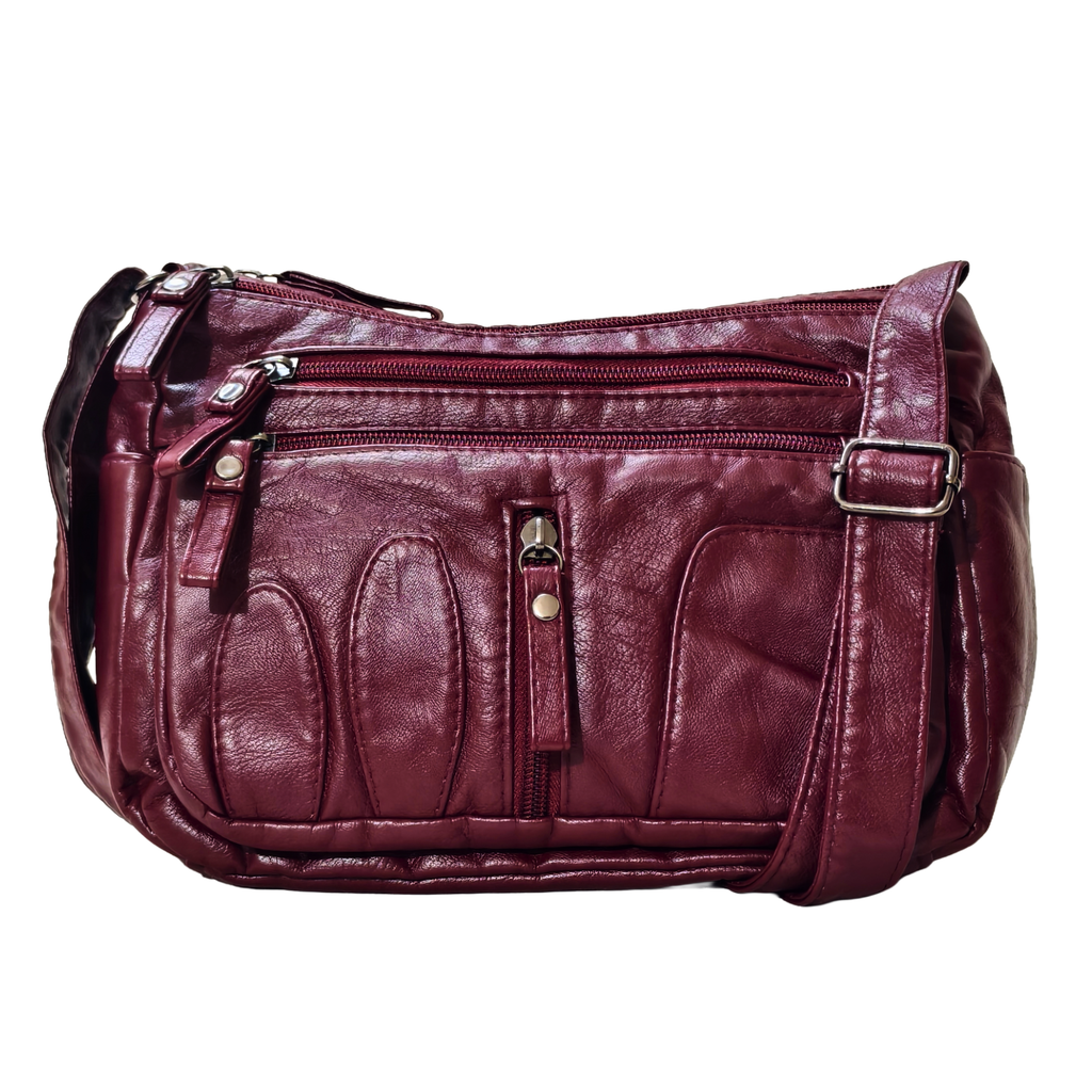 Maroon leather handbag with multiple pockets and zippers on a white background