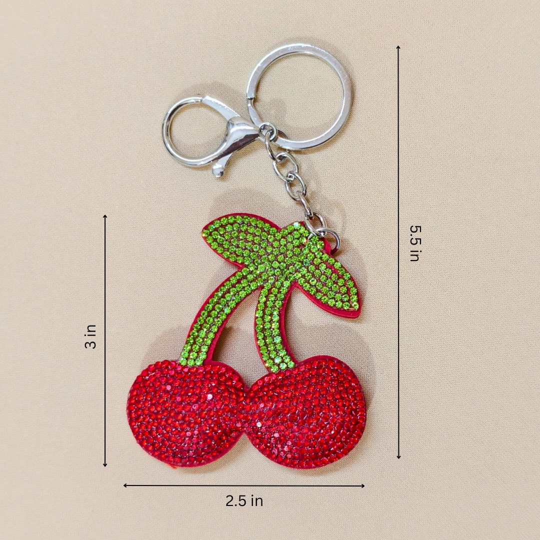 cherry keychain with a metal latch in front of a beige background