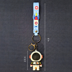 Keychain with astronaut design and measurement details on a dark background